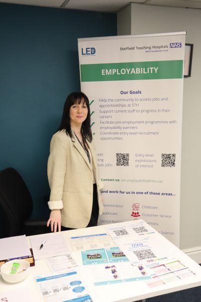 a woman stands in front of an employability banner